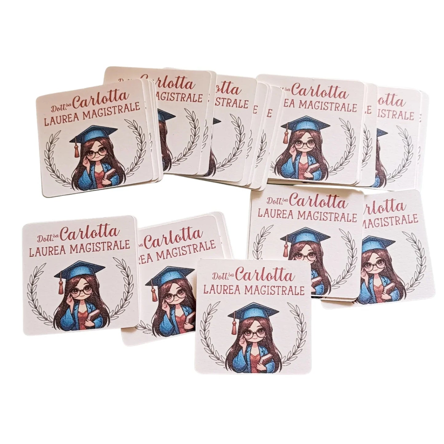 Square graduation stickers with cartoon girl in cap and gown, laurels, and 'Dott.ssa Carlotta Laurea Magistrale' text.