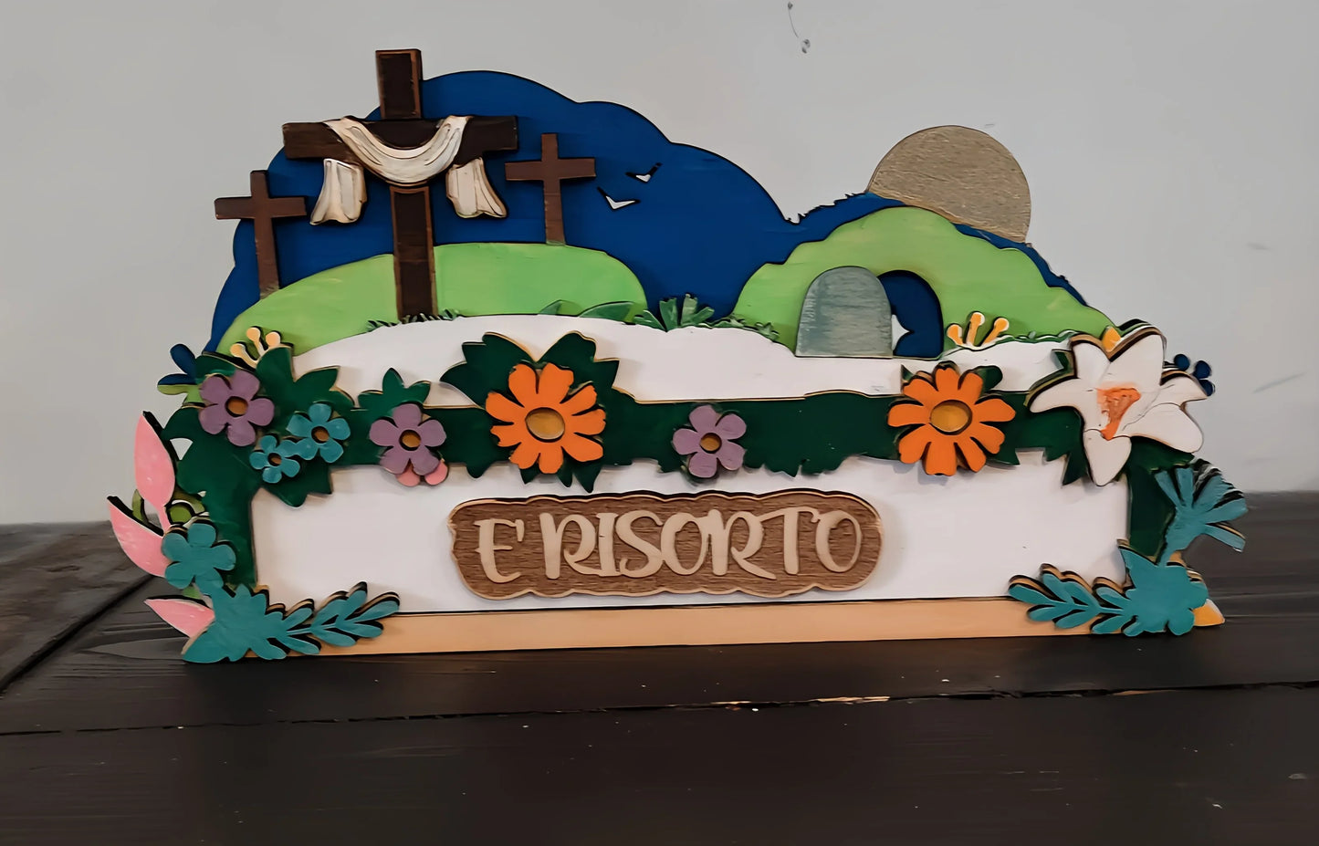 Colorful wooden Easter Resurrection decoration with crosses, flowers, and 'E RISORTO' sign