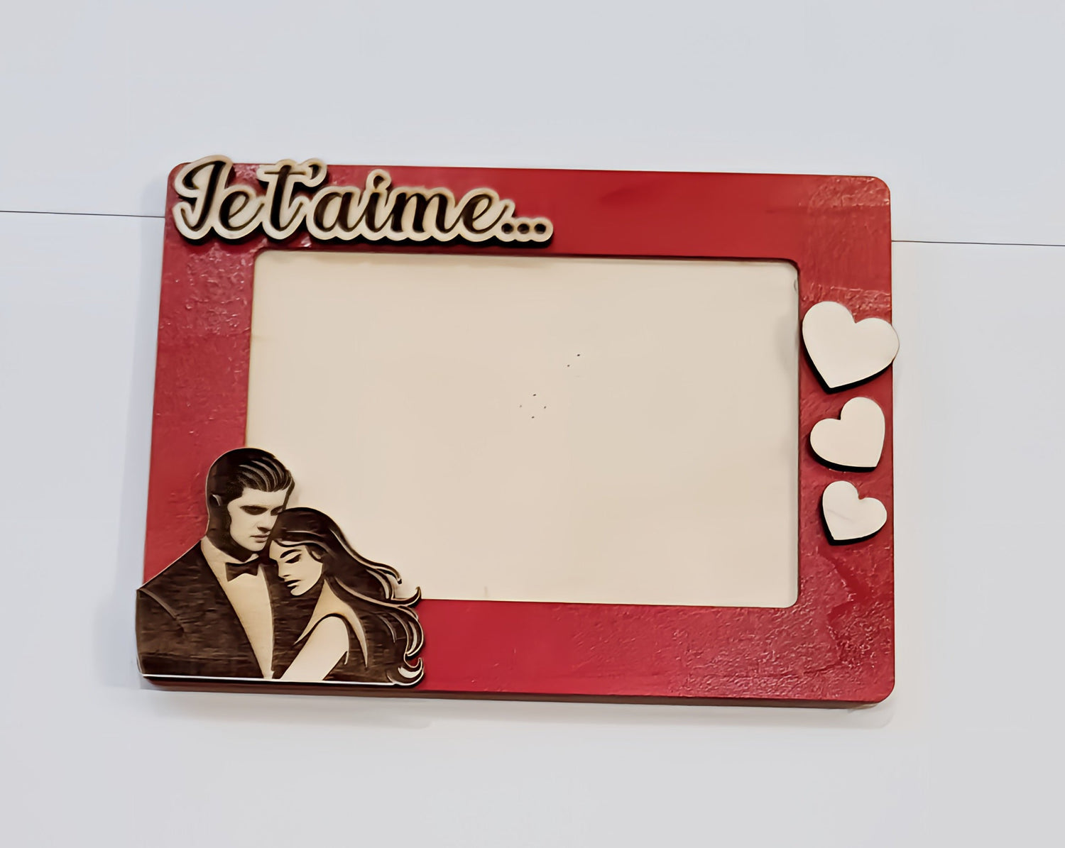 Red romantic photo frame with 'Je t'aime,' couple illustration, and heart decorations