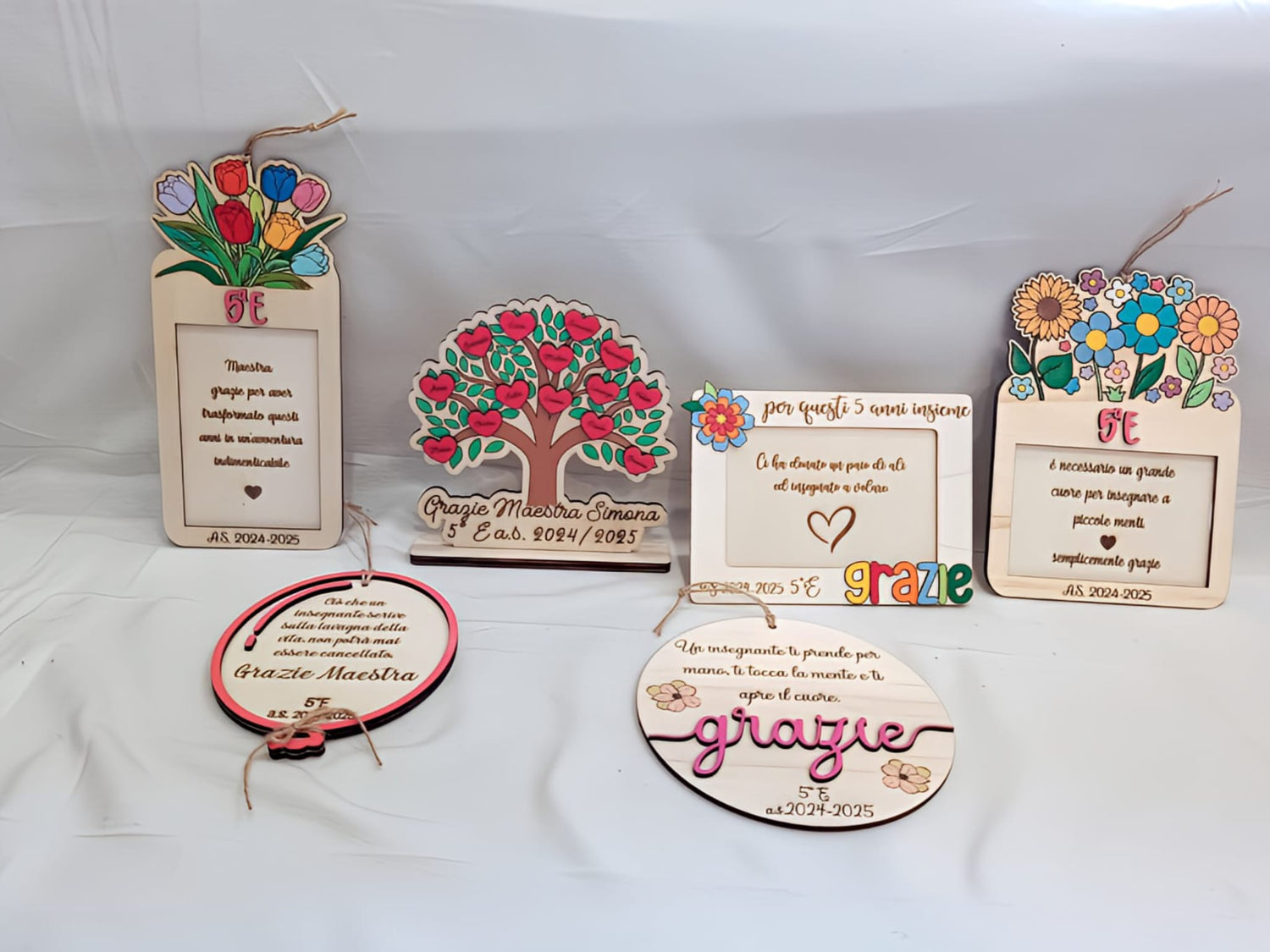 Wooden teacher appreciation plaques with colorful floral and heart designs, class 5E, Italian text.