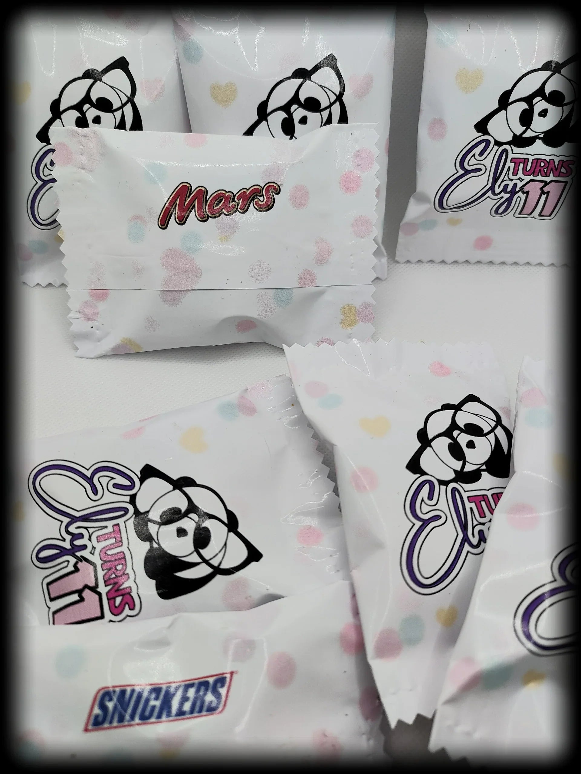 Custom candy wrappers with cartoon bear, Mars and Snickers logos, pastel heart pattern