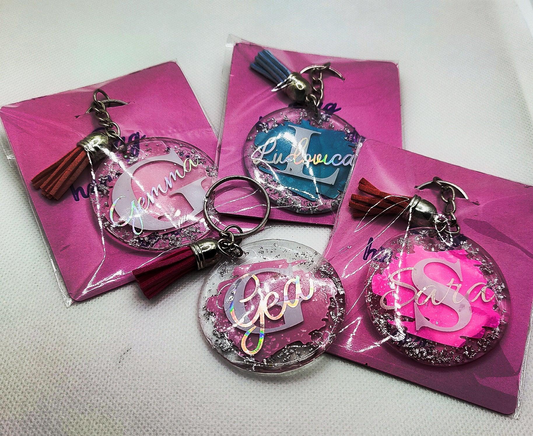 Personalized resin keychains with names and tassels on pink cards, custom gift idea