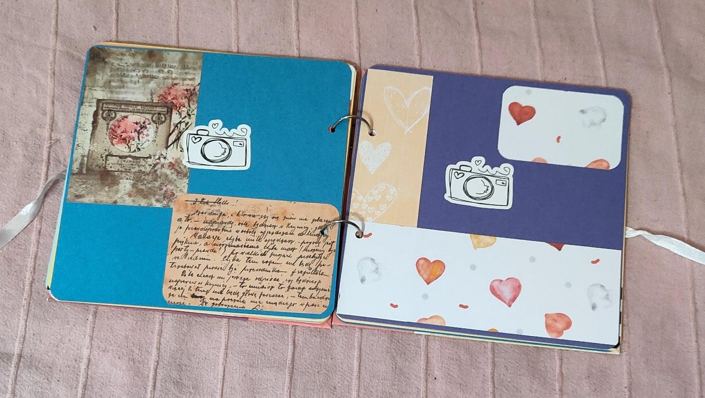 Handmade scrapbook layout with vintage paper, camera stickers, and heart decorations