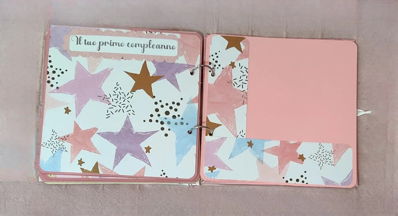 Scrapbook page for baby's first birthday with pastel stars and pink background