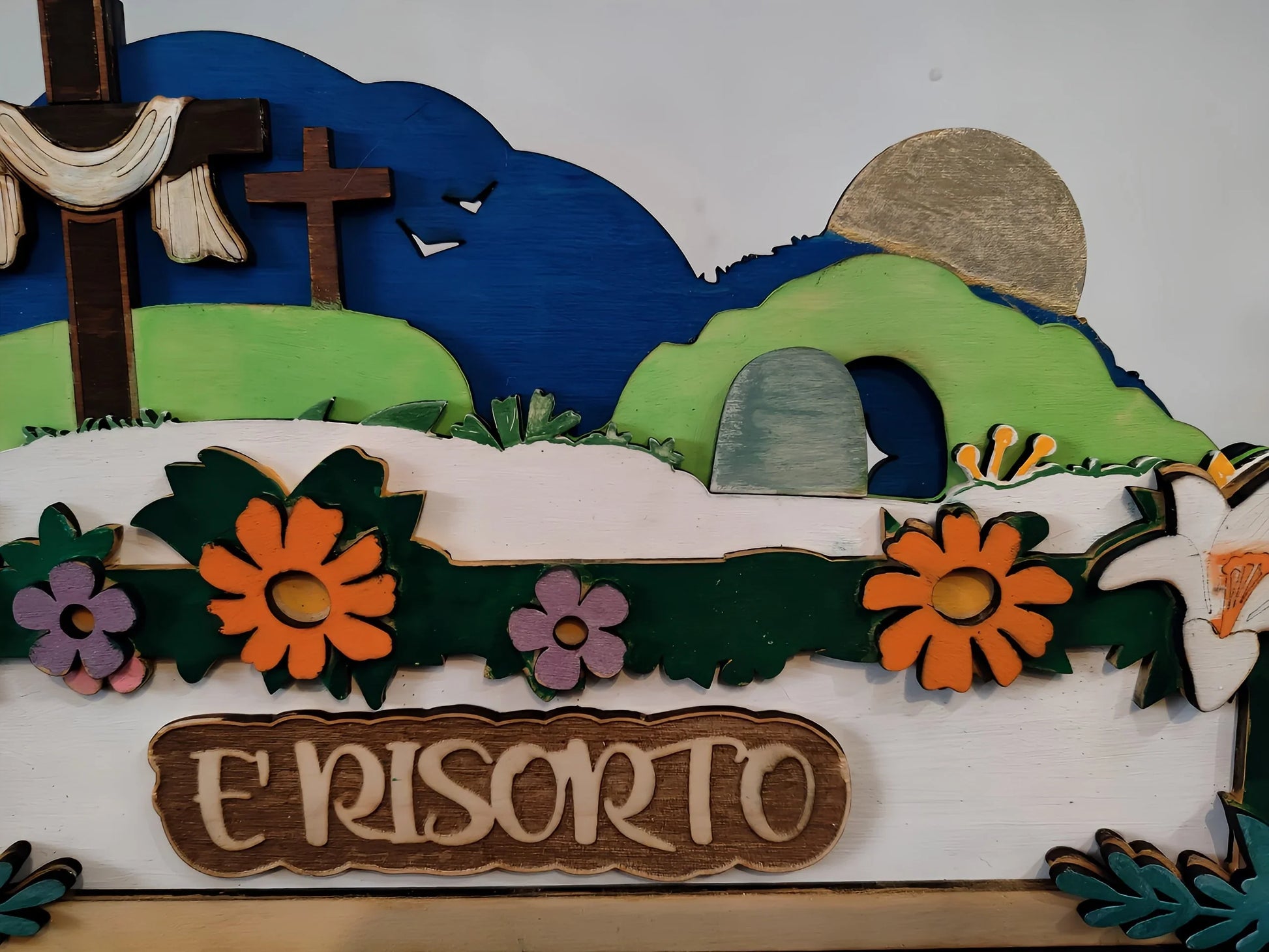 Wooden Easter scene with crosses, empty tomb, flowers, and 'E' RISORTO' sign