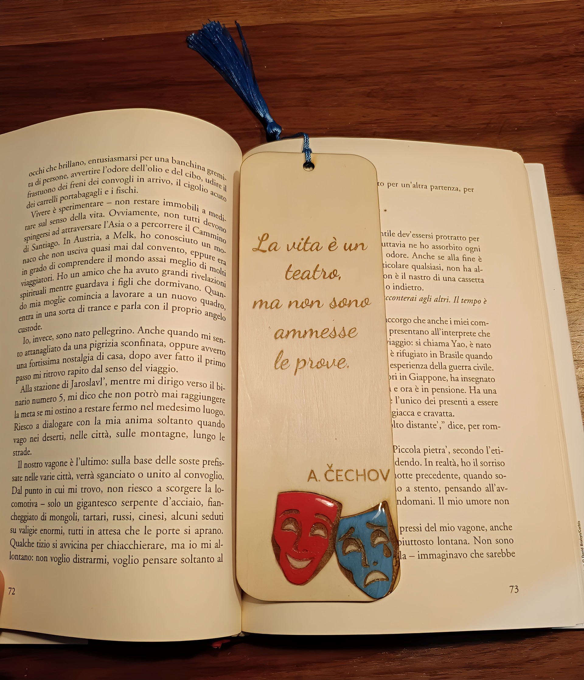 Open book with Italian text, wooden theatrical bookmark with comedy and tragedy masks, quote by Chekhov.