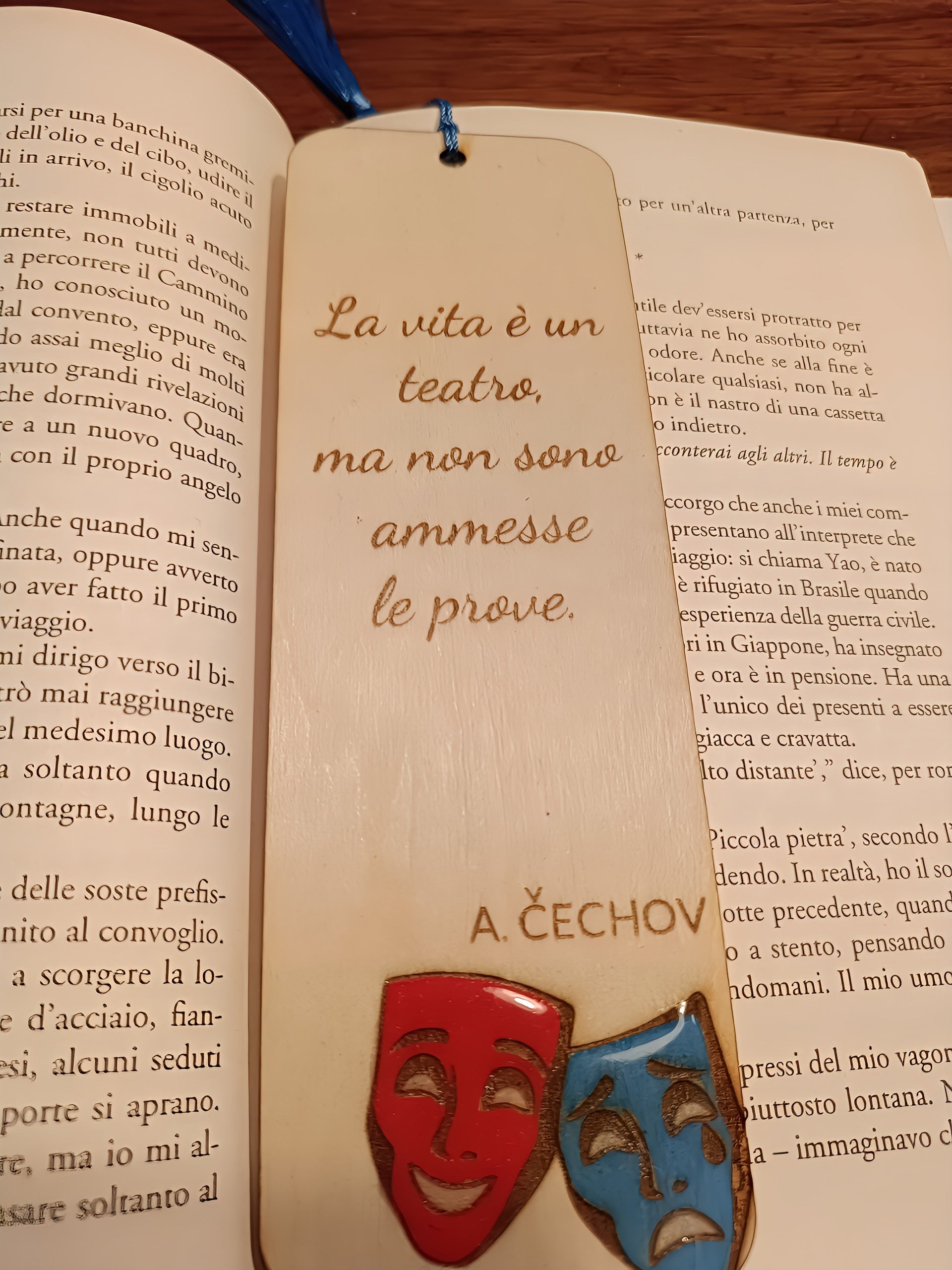 Italian book open with a wooden bookmark featuring theatrical masks and Chekhov quote