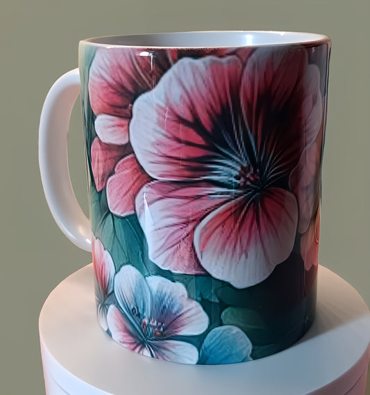 Ceramic mug with pink and blue floral design on display against neutral background