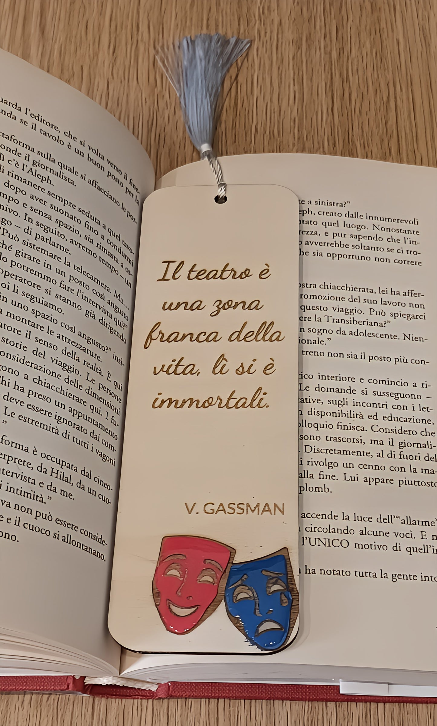 Wooden bookmark with Italian quote, blue tassel, and comedy-tragedy masks in open book