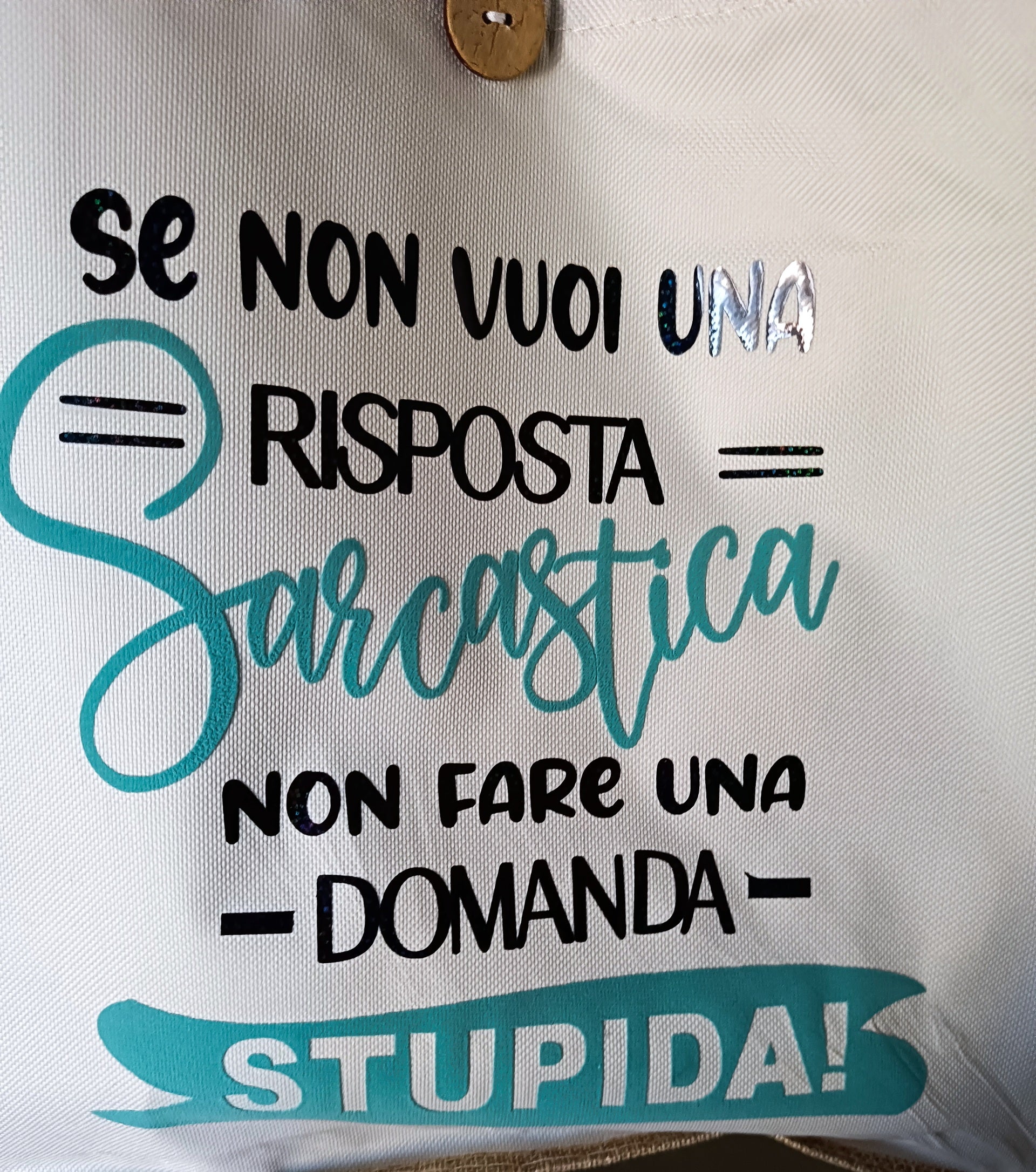 Italian text tote bag with bold phrase 'Se non vuoi una risposta sarcastica non fare una domanda stupida' on white fabric.