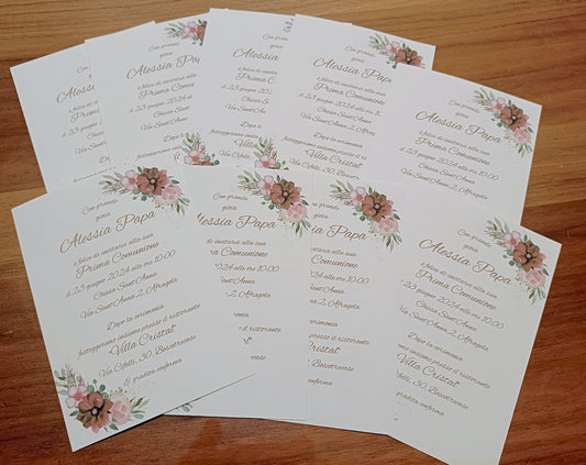 Floral Prima Comunione invitations with pink flowers on a wood surface, Italian text visible