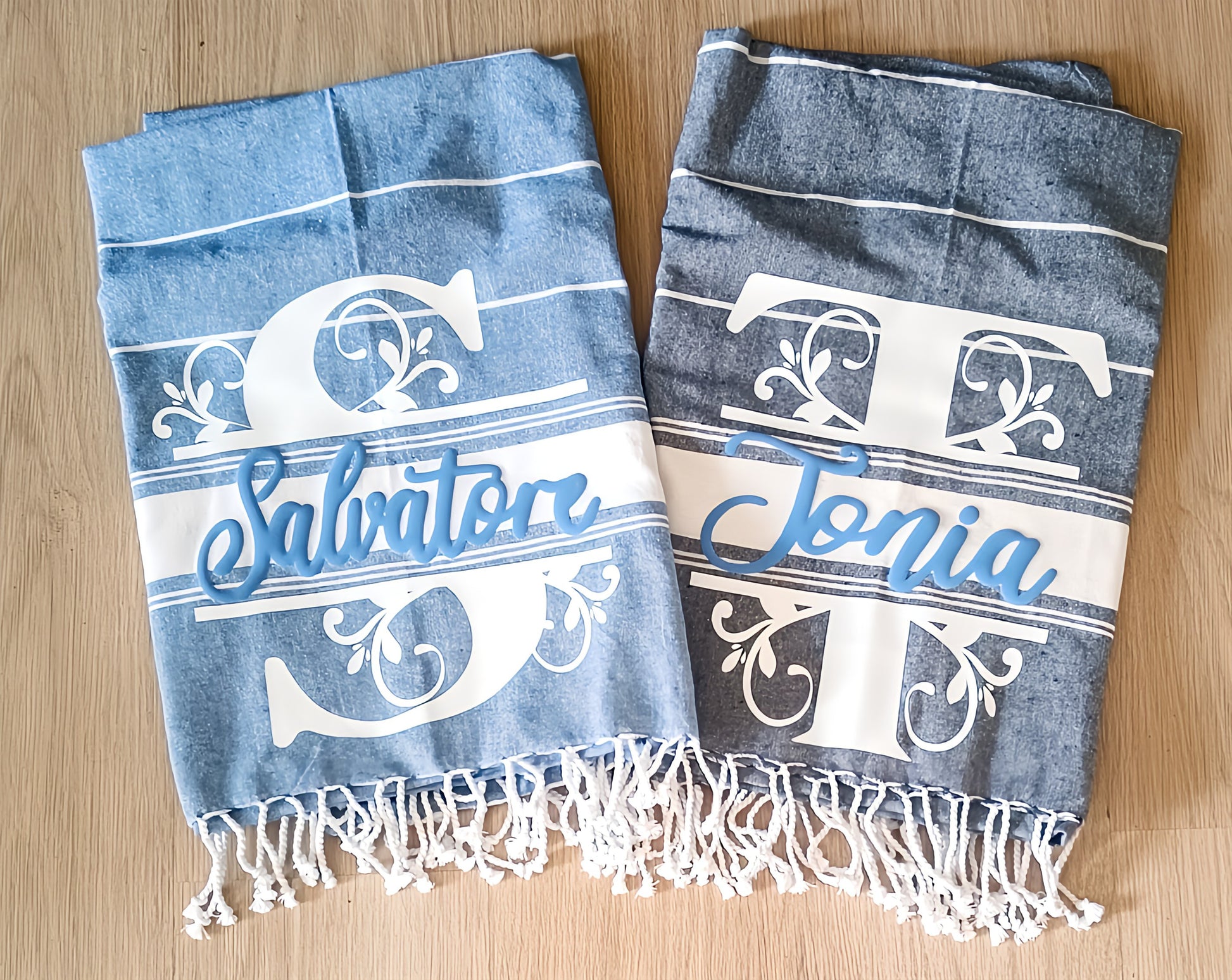 Personalized blue and gray towels with names Salvatore and Tonia, decorative letters, on wood floor