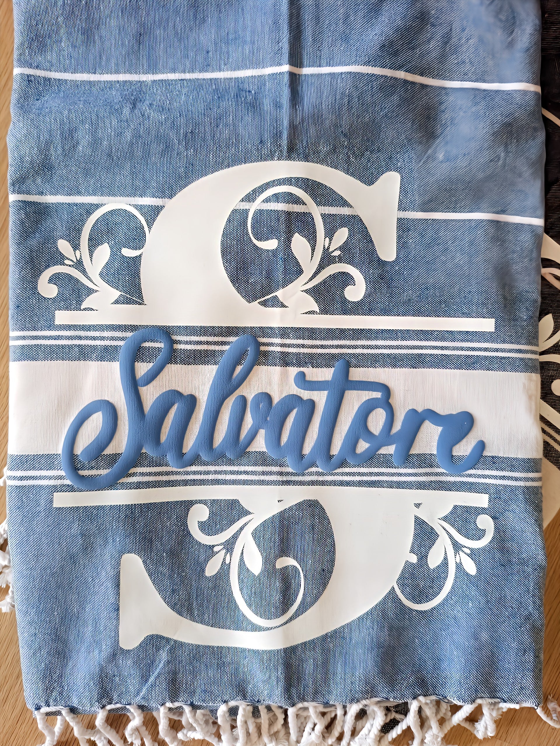 Blue and white monogram towel with decorative letter S and Salvatore name, tassel fringe