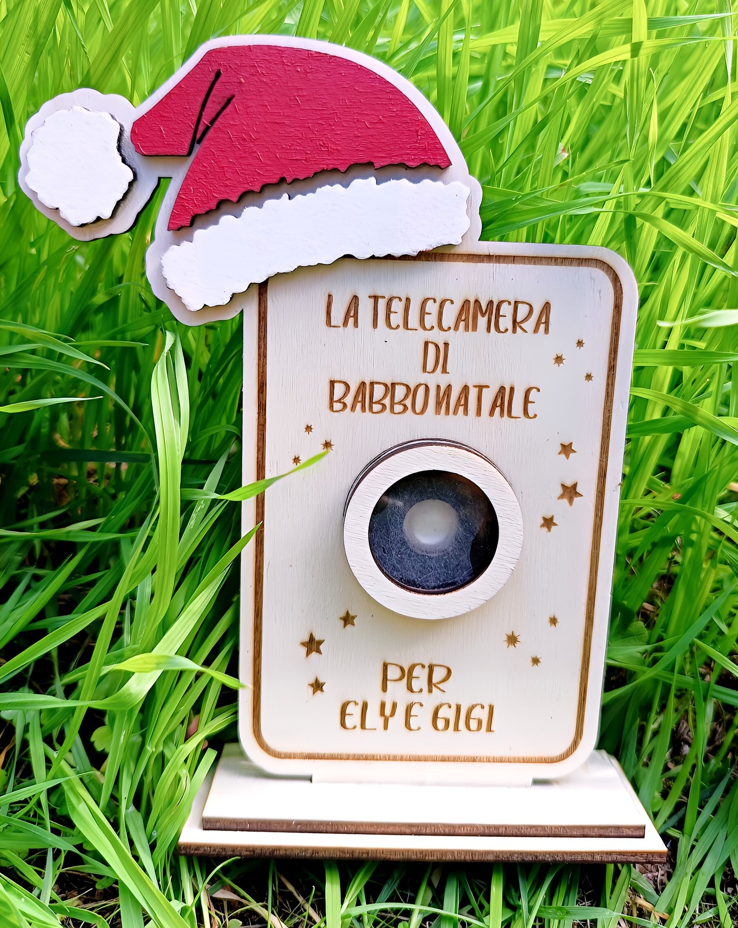 Wooden Santa camera ornament with red hat, personalized, in green grass