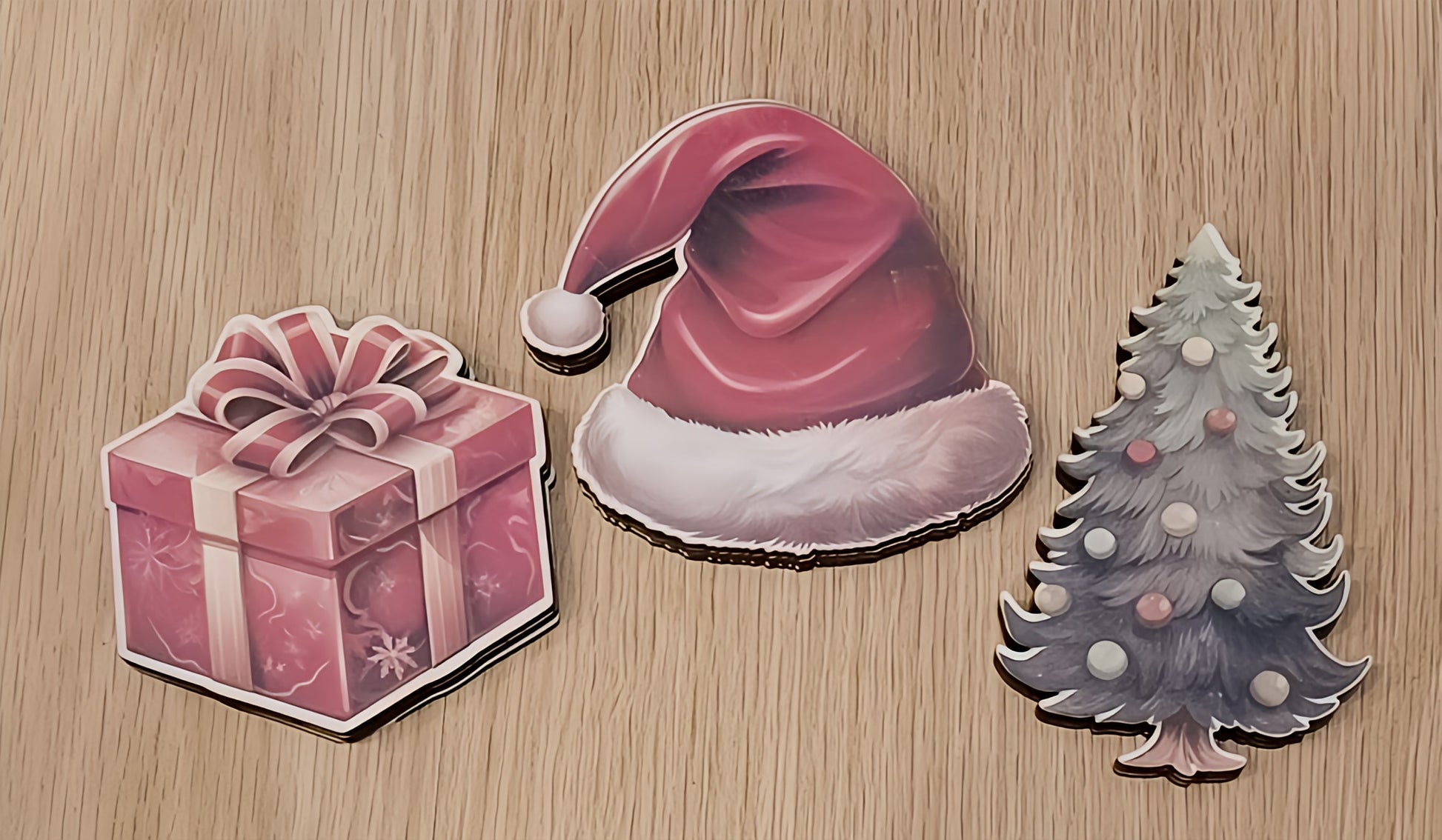 Christmas stickers of a gift box, Santa hat, and Christmas tree on wooden background