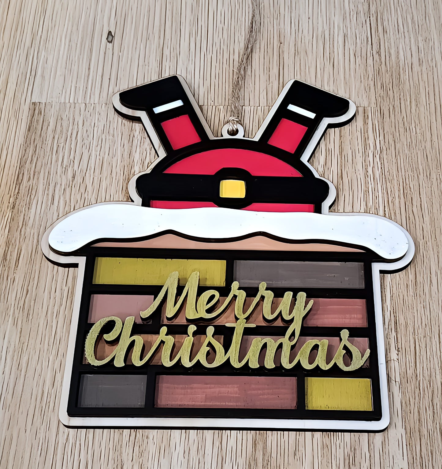 Santa Claus legs in chimney Merry Christmas ornament on wooden background