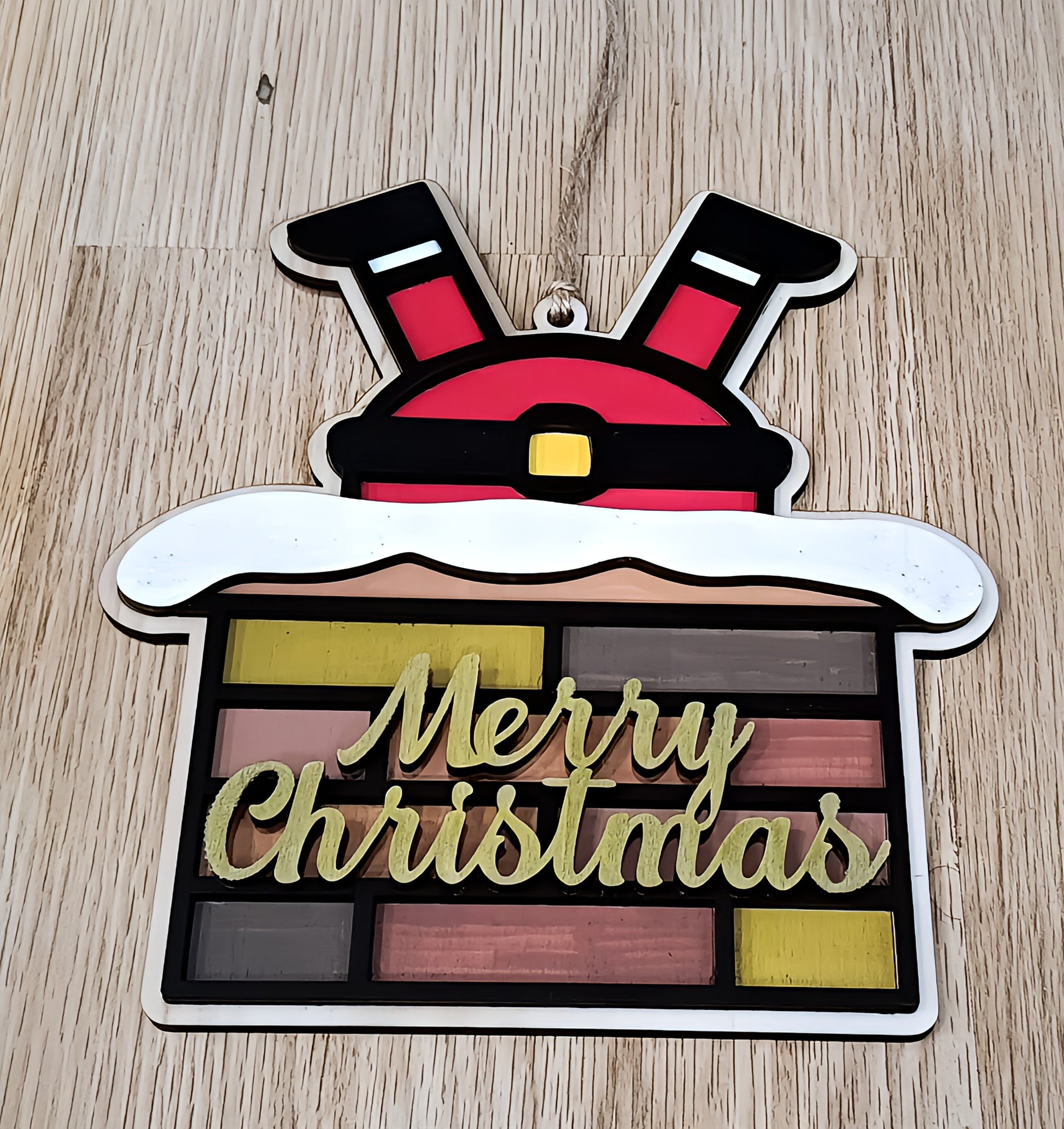 Santa Claus legs in chimney Merry Christmas ornament on wooden background