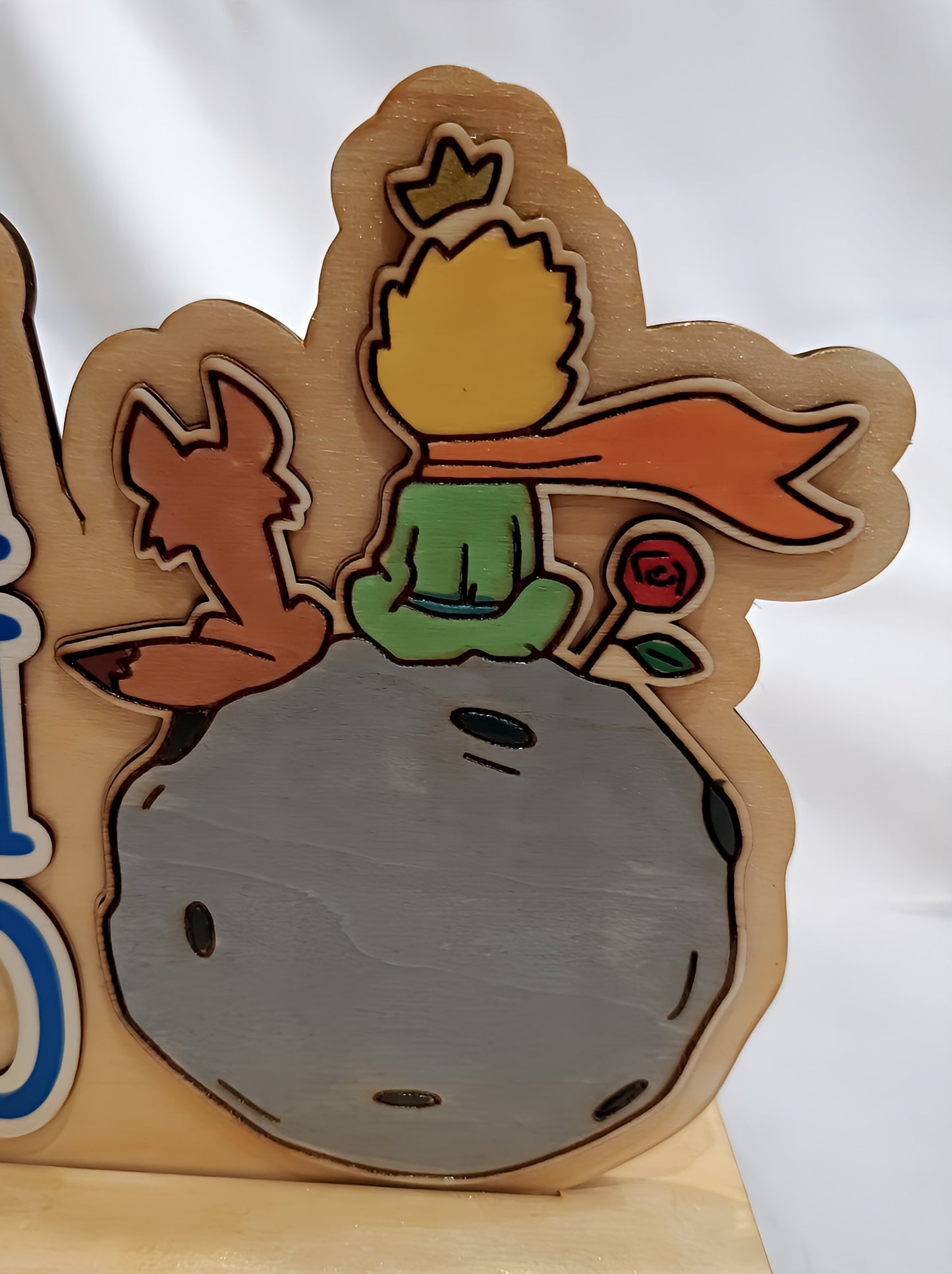 Wooden plaque of Little Prince, fox, and rose on asteroid with white background