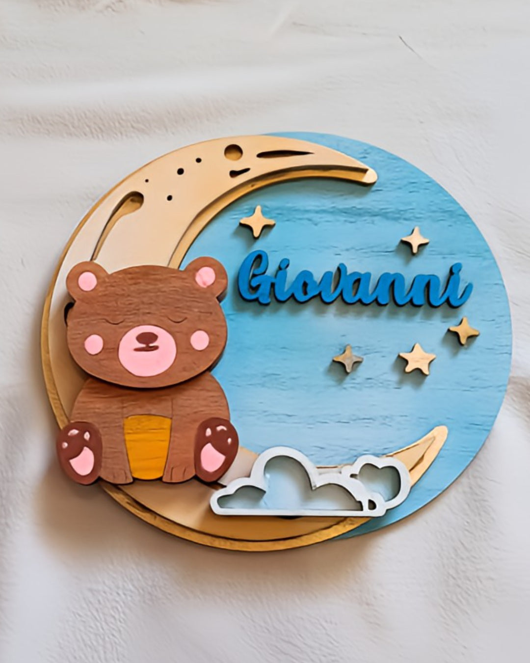 Wooden nursery wall decor with bear, moon, stars, clouds, and name Giovanni on blue circle