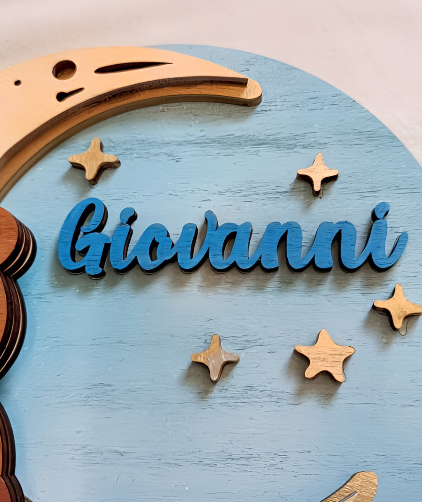 Custom wooden name sign with 'Giovanni,' moon, and stars on a blue background