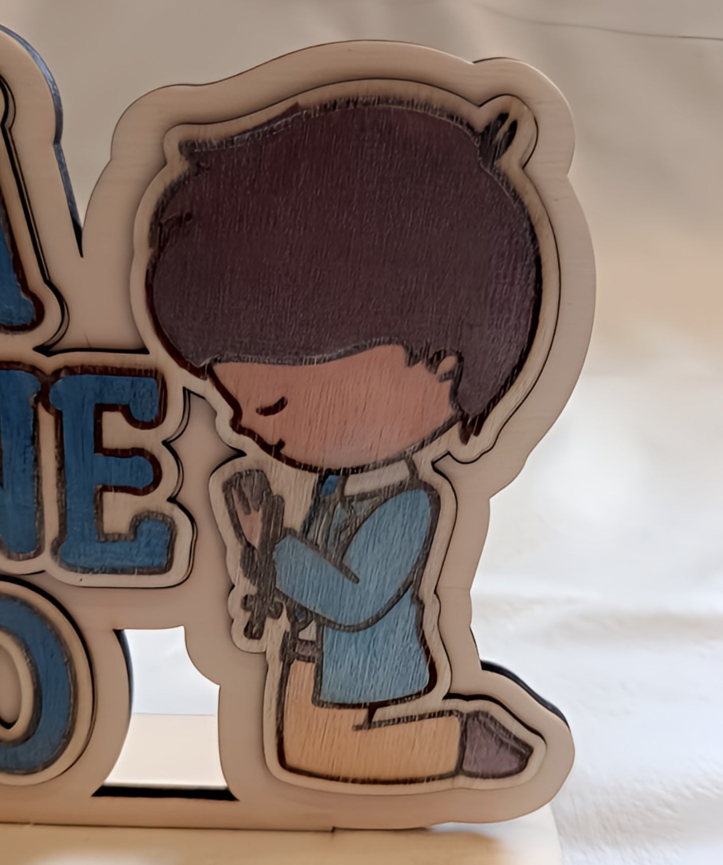 Cartoon boy kneeling and praying, wooden decor with blue jacket and cross