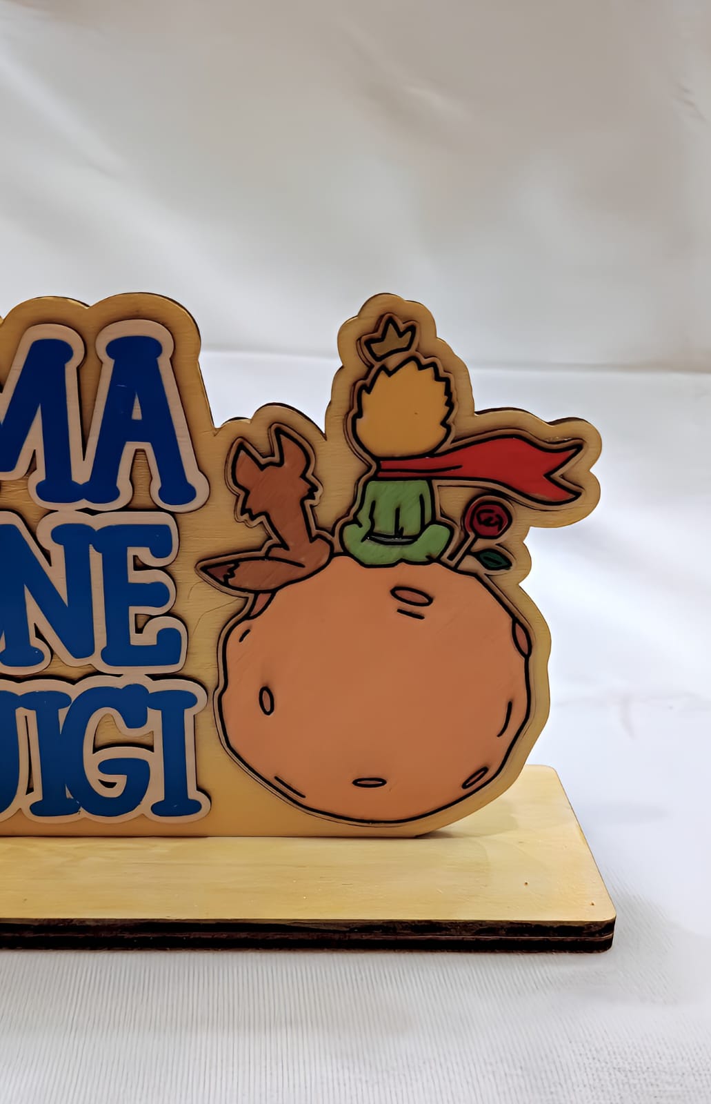 Wooden plaque of The Little Prince sitting on his planet with a fox and a red rose