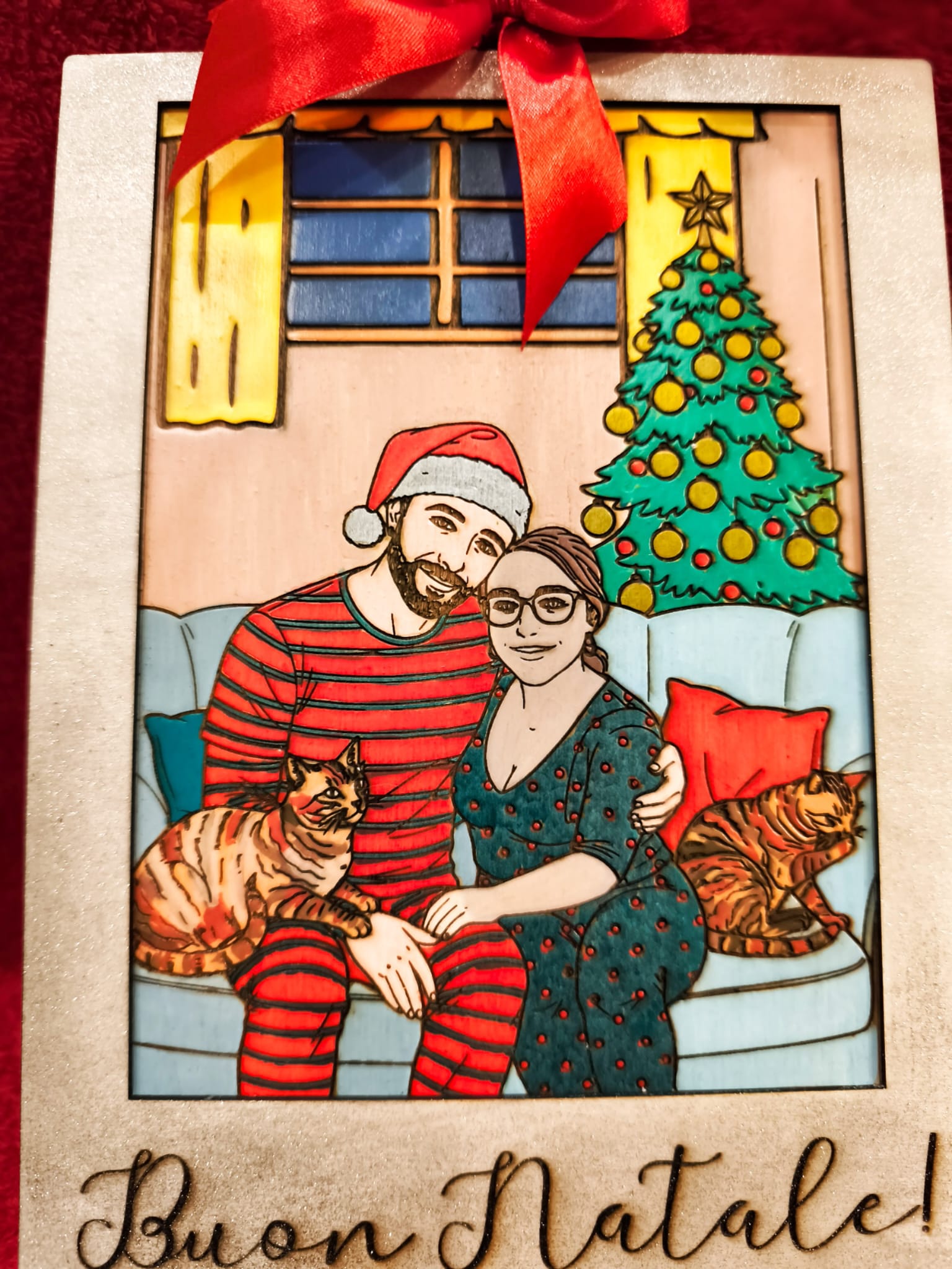 coppia in abiti natalizi seduta su divano con gatti