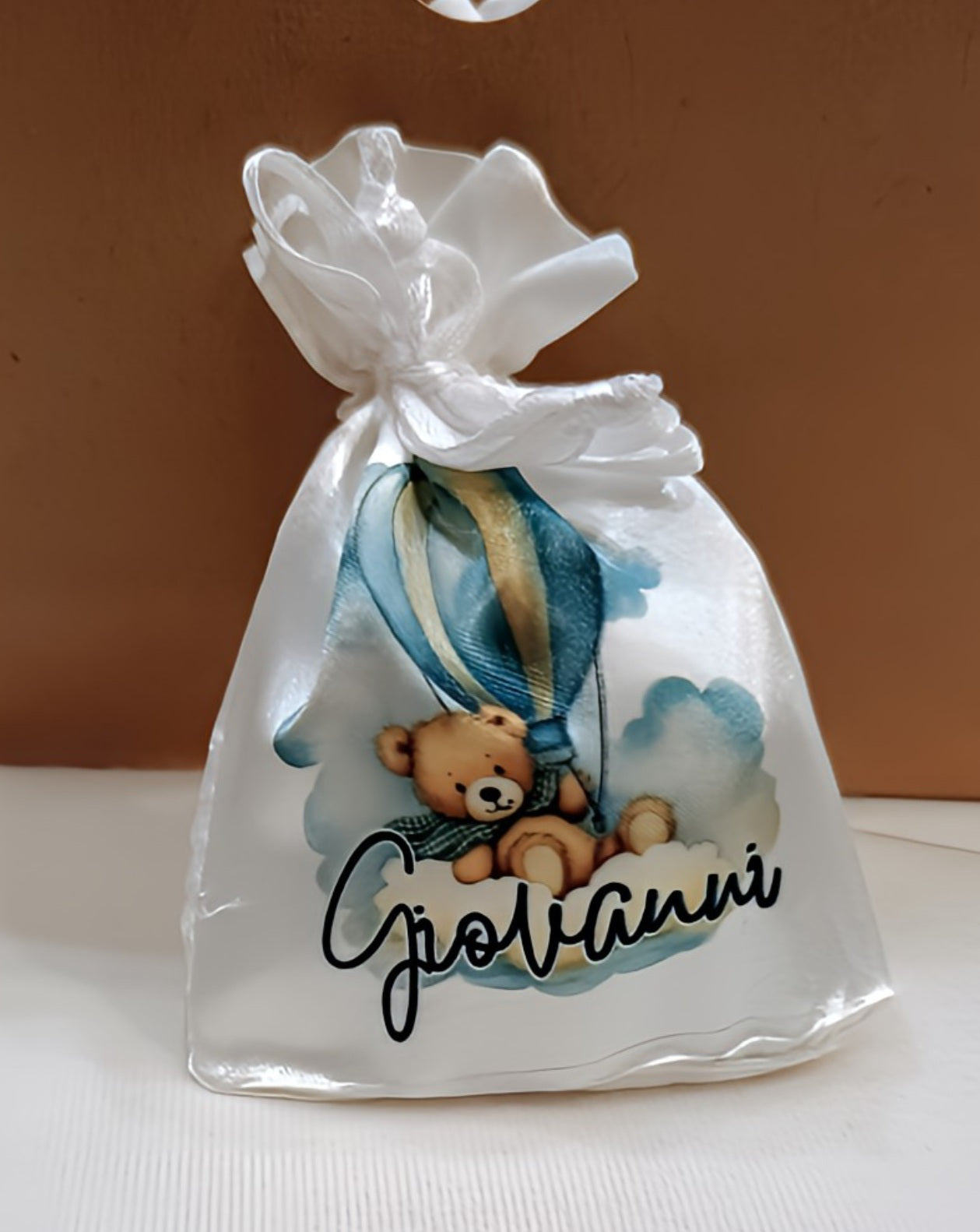 White gift bag with teddy bear hot air balloon design, 'Giovanni' text, ribbon bow